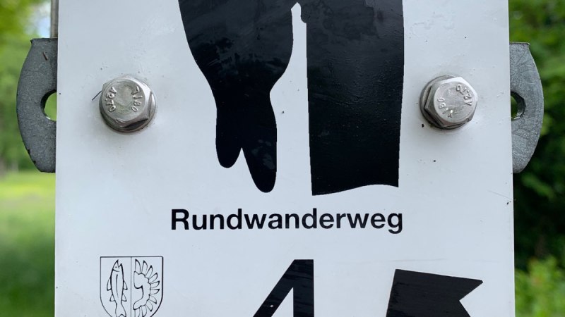 Schild mit Specht-Symbol für Rundwanderweg 4 in Remseck am Neckar, befestigt an einem Pfosten.