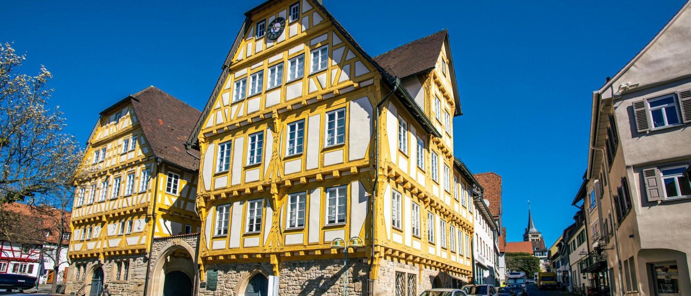 Ein beeindruckendes Fachwerkhaus in Sindelfingen, umgeben von blühenden Bäumen und einem klaren blauen Himmel., © Stuttgart-Marketing GmbH, Sarah Schmid