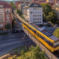 Die Zahnradbahn in Stuttgart f&auml;hrt auf einer erh&ouml;hten Schiene durch eine st&auml;dtische Umgebung mit historischen Geb&auml;uden und B&auml;umen., &copy; SMG, Achim Mende