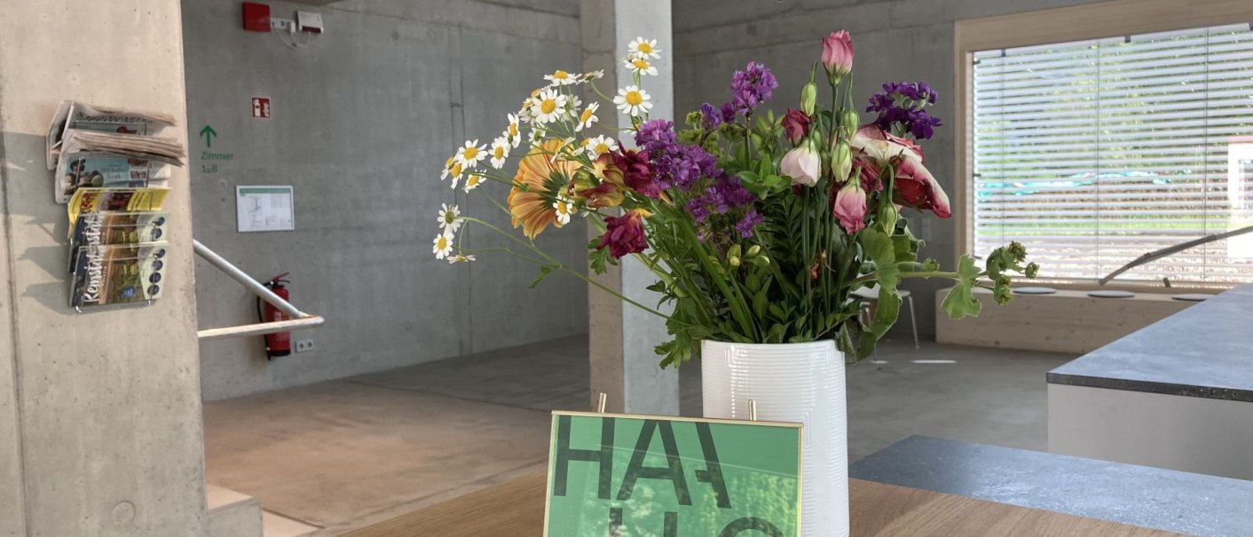 Moderner Eingangsbereich mit Betonwänden, einem Blumenstrauß auf einem Tisch und Zeitschriften an der Wand., © Remstal Tourismus e.V. Moderner Eingangsbereich mit Betonwänden, einem Blumenstrauß auf einem Tisch und Zeitschriften an der Wand., © Remstal Tourismus e.V.