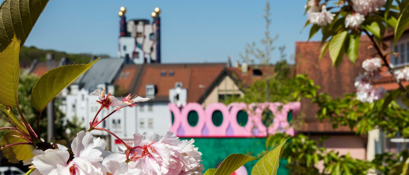Kirschblüten im Vordergrund, bunte Architektur im Hintergrund in Plochingen, sonniger Tag., © Stuttgart-Marketing GmbH