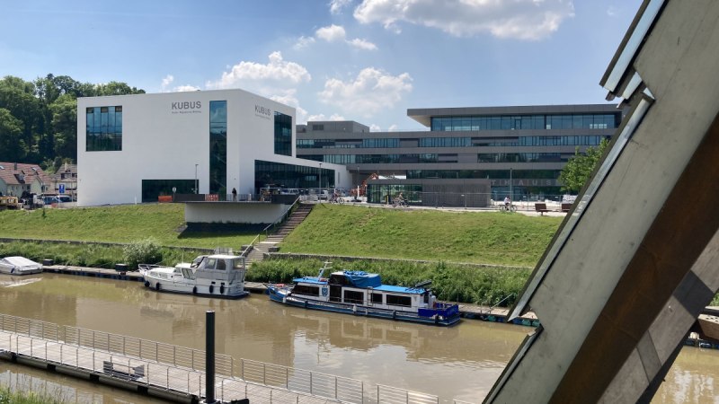 Moderne Geb&auml;ude am Flussufer in Remseck am Neckar, mit Booten im Wasser und einem klaren Himmel im Hintergrund., &copy; Remstal Tourismus e. V.