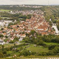 Panoramablick auf Besigheim, umgeben von grünen Weinbergen und Fluss. Historische Gebäude und moderne Strukturen prägen das Stadtbild., © SMG, Sarah Schmid