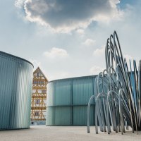 Moderne Skulptur vor einem Fachwerkhaus in Waiblingen. Im Hintergrund Wolken am Himmel. Logo von 'Wanderbares Deutschland' oben rechts., © Unbekannt