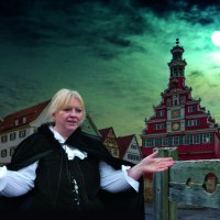 Eine Frau in historischer Kleidung steht vor dem Alten Rathaus in Esslingen. Der Vollmond leuchtet am Nachthimmel., &copy; Esslinger Stadtmarketing &amp; Tourismus GmbH