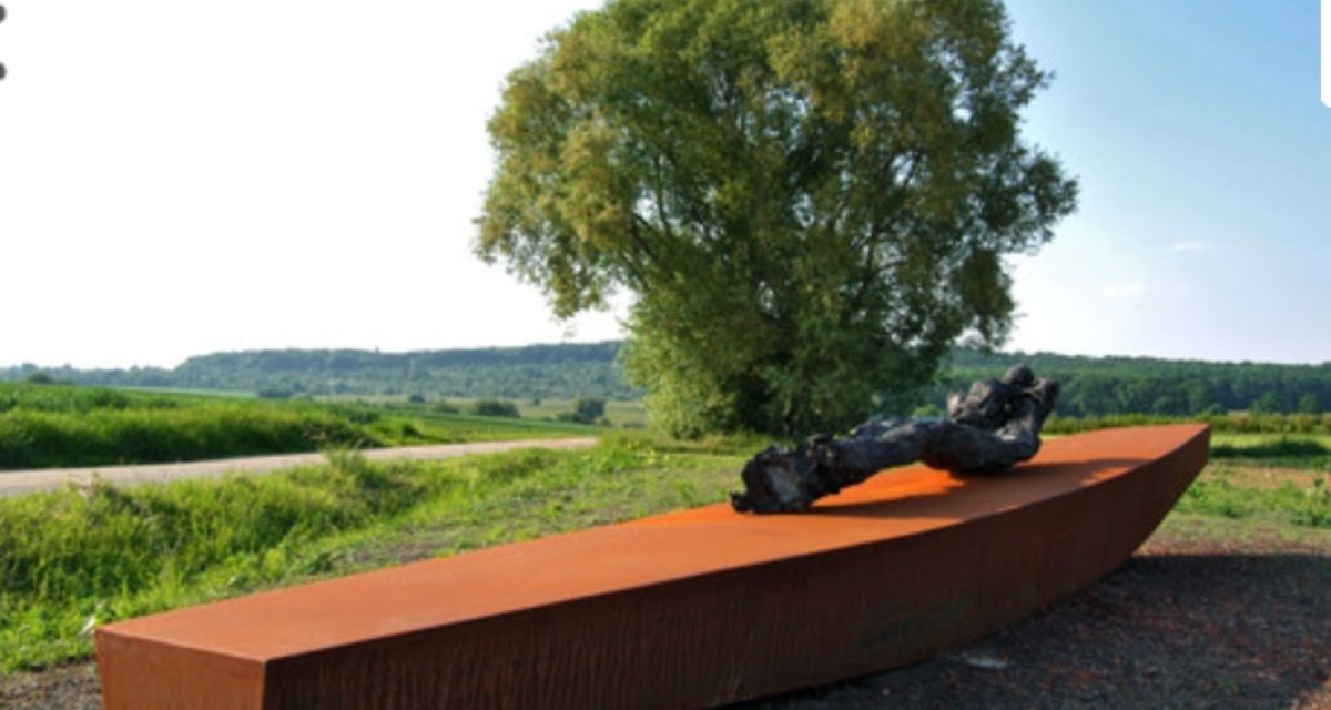 Eine rostfarbene Skulptur auf dem Besinnungsweg Fellbach, umgeben von grüner Landschaft und einem großen Baum im Hintergrund., © www.besinnungsweg-fellbach.de Eine rostfarbene Skulptur auf dem Besinnungsweg Fellbach, umgeben von grüner Landschaft und einem großen Baum im Hintergrund., © www.besinnungsweg-fellbach.de