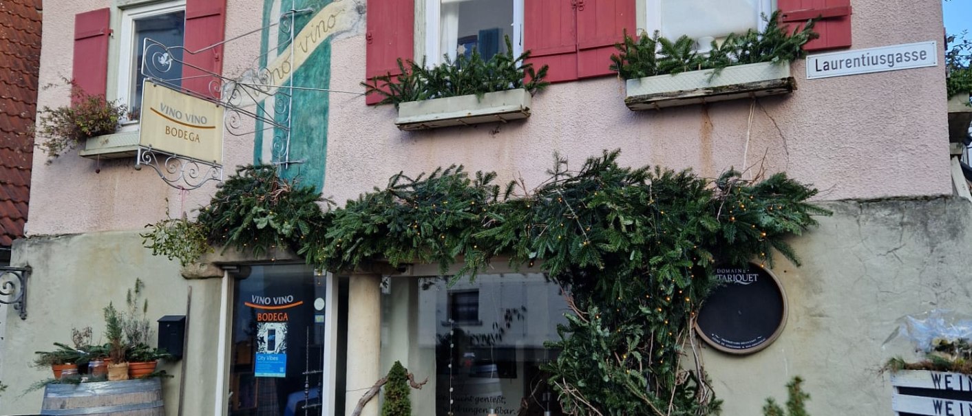Ein Geb&auml;ude mit roten Fensterl&auml;den und weihnachtlicher Dekoration. Ein Schild zeigt 'Vino Vino Bodega'., &copy; StadtNuertingen