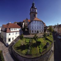 Panorama von Backnang mit Fachwerkhäusern, einem Kirchturm und blühenden Gärten unter strahlend blauem Himmel und Sonnenschein., © Stuttgart-Marketing GmbH