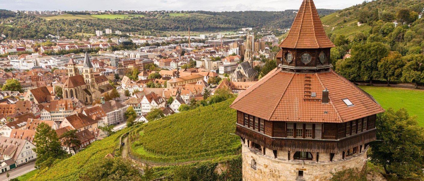 Panoramablick auf Esslingen mit einem historischen Turm im Vordergrund und Weinbergen im Hintergrund., © Stuttgart-Marketing GmbH, Sarah Schmid Panoramablick auf Esslingen mit einem historischen Turm im Vordergrund und Weinbergen im Hintergrund., © Stuttgart-Marketing GmbH, Sarah Schmid