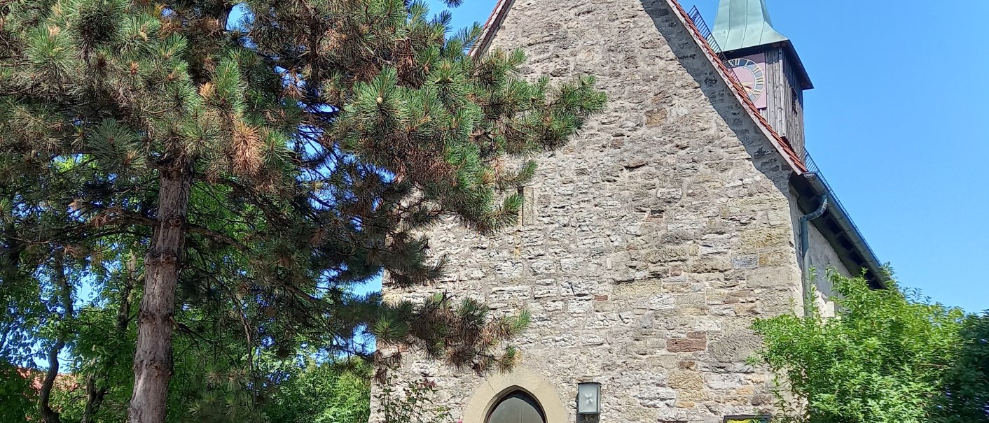 Die Westseite der Bartholom&auml;uskirche in Gro&szlig;altdorf zeigt eine steinerne Fassade mit einem Dachreiter. Ein gro&szlig;er Baum steht im Vordergrund., &copy; Petra Natzkowski