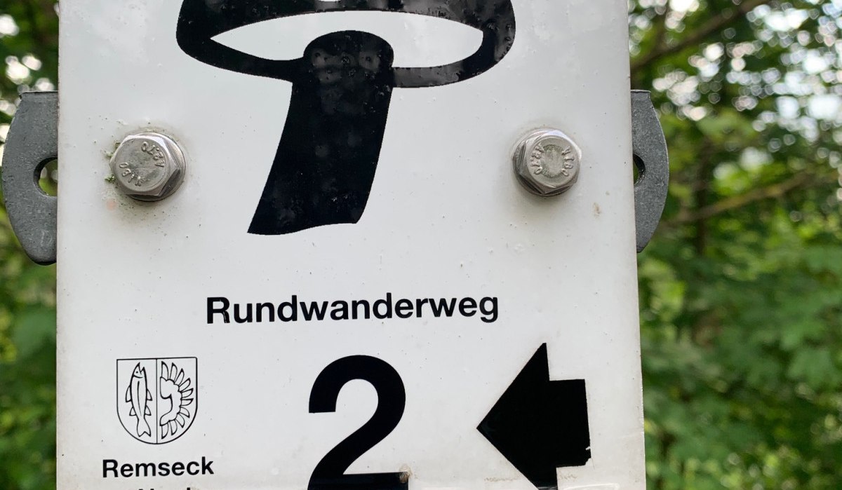 Ein Schild mit einem Pilzsymbol zeigt den Rundwanderweg 2 in Remseck am Neckar an. Der Pfeil weist nach links. Ein Schild mit einem Pilzsymbol zeigt den Rundwanderweg 2 in Remseck am Neckar an. Der Pfeil weist nach links.