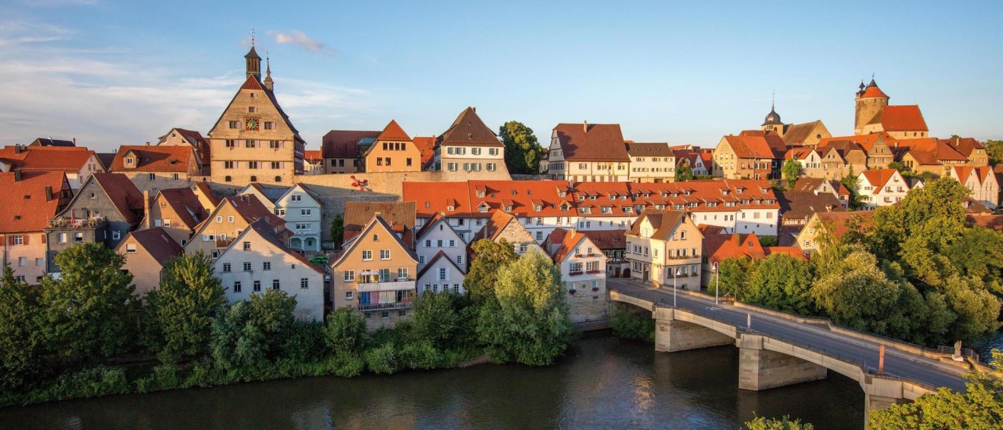 Panorama der malerischen Altstadt von Besigheim mit roten Dächern und der Enz im Vordergrund, beleuchtet von der Abendsonne., © SMG, Achim Mende Panorama der malerischen Altstadt von Besigheim mit roten Dächern und der Enz im Vordergrund, beleuchtet von der Abendsonne., © SMG, Achim Mende