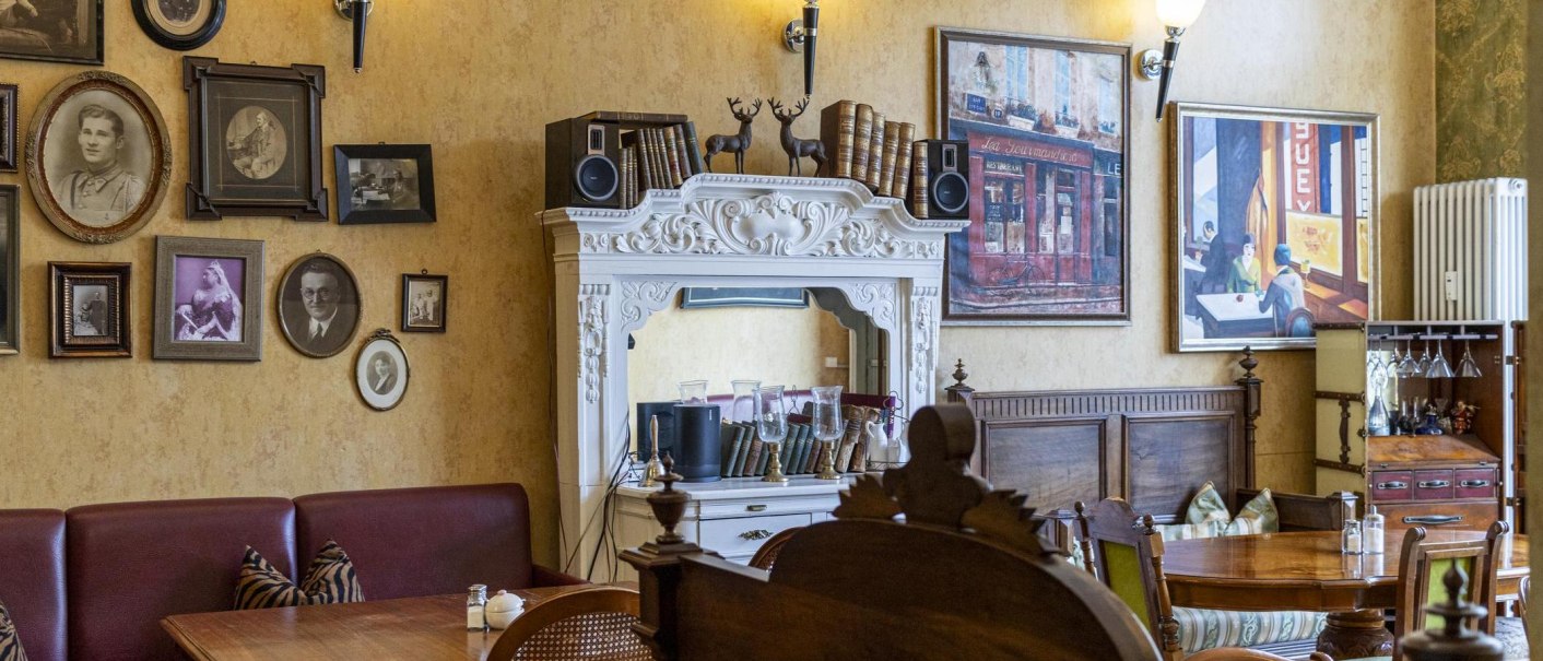 Ein gemütliches Café mit antiken Möbeln, gerahmten Bildern und dekorativen Elementen an den Wänden., © SMG, Sarah Schmid
