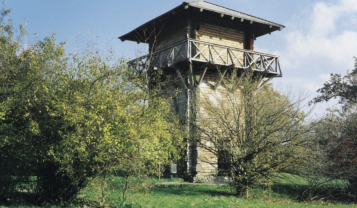 Rekonstruierter römischer Wachturm aus Holz mit umlaufendem Balkon, umgeben von Bäumen und Büschen auf einer grünen Wiese., © Remstal Tourismus e.V.