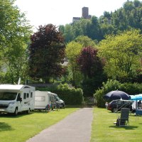 Campingplatz mit Wohnmobilen und Zelten, umgeben von grünen Bäumen und Hügeln. Im Hintergrund ist eine Burg auf einem Hügel zu sehen., © Campingpark Bad Liebenzell, Andreas Harter Campingplatz mit Wohnmobilen und Zelten, umgeben von grünen Bäumen und Hügeln. Im Hintergrund ist eine Burg auf einem Hügel zu sehen., © Campingpark Bad Liebenzell, Andreas Harter