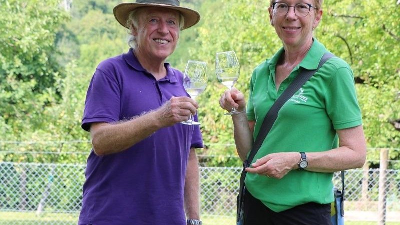 Zwei Personen sto&szlig;en mit Weingl&auml;sern in einem gr&uuml;nen Garten an. Sie tragen Freizeitkleidung und l&auml;cheln in die Kamera., &copy; Foto: TELB, Manuela Priber