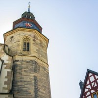 Turm einer Stadtkirche mit Uhr, daneben ein Fachwerkhaus. Der Himmel ist klar und blau., © Stuttgart-Marketing GmbH, Sarah Schmid Turm einer Stadtkirche mit Uhr, daneben ein Fachwerkhaus. Der Himmel ist klar und blau., © Stuttgart-Marketing GmbH, Sarah Schmid