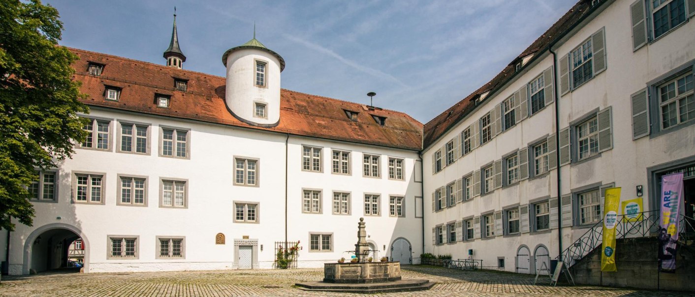 Der Innenhof von Schloss Waldenbuch zeigt wei&szlig;e Geb&auml;ude mit roten D&auml;chern und einen zentralen Brunnen. Ein blauer Himmel rundet die Szene ab., &copy; Stuttgart-Marketing GmbH, Sarah Schmid