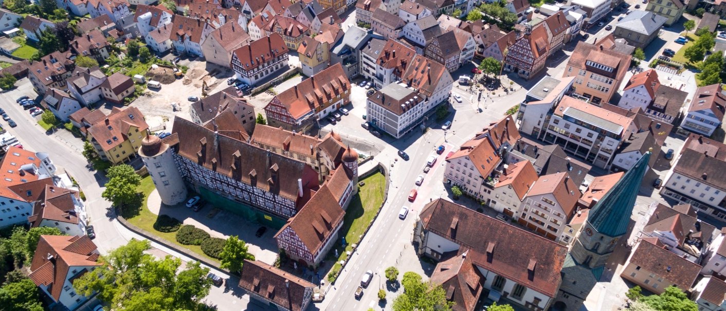 Luftaufnahme einer historischen Altstadt mit Fachwerkhäusern, Schloss und Kirche. Die Straßen sind von Bäumen gesäumt., © Stadt Gaildorf Luftaufnahme einer historischen Altstadt mit Fachwerkhäusern, Schloss und Kirche. Die Straßen sind von Bäumen gesäumt., © Stadt Gaildorf