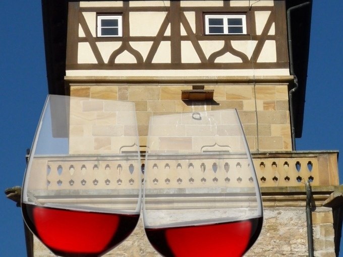 Zwei gef&uuml;llte Weingl&auml;ser vor einem historischen Fachwerkgeb&auml;ude mit blauer Himmel im Hintergrund., &copy; WTM GmbH Waiblingen