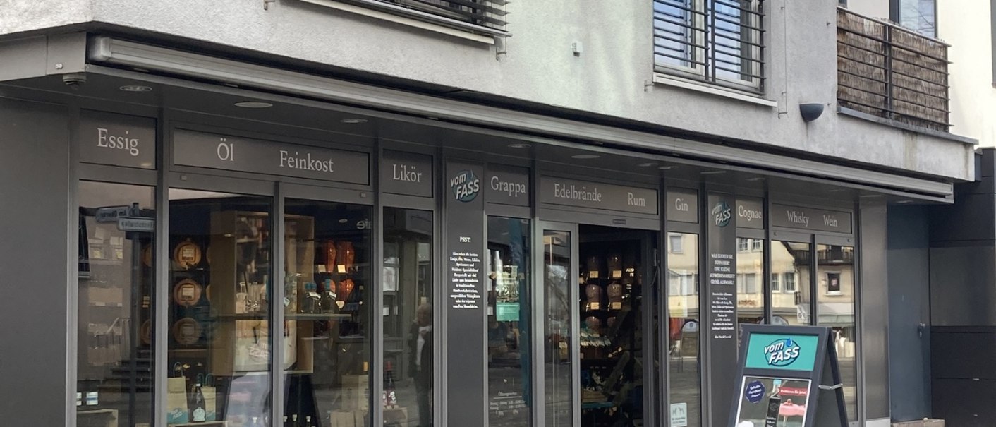 Geschäftsfassade von 'Vom Fass' in Nürtingen mit Schaufenstern und einem Werbeschild auf dem Gehweg., © Lena Besemer