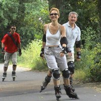 Drei Personen fahren auf einem Waldweg Inlineskates. Sie tragen Schutzkleidung und lächeln. Die Umgebung ist grün und bewaldet., © Natur.Nah. Schönbuch & Heckengäu