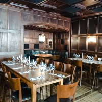 Elegantes Restaurant mit Holzw&auml;nden, gedeckten Tischen und Kerzenlicht. Dunkle Holzm&ouml;bel und eine gem&uuml;tliche Atmosph&auml;re dominieren den Raum., &copy; Weinstube Fr&ouml;hlich Verwaltungs GmbH