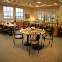 Ein elegantes Restaurant mit gedeckten Tischen, Stühlen und dekorativen Blumen. Große Fenster lassen viel Licht herein., © ateckhotel Ein elegantes Restaurant mit gedeckten Tischen, Stühlen und dekorativen Blumen. Große Fenster lassen viel Licht herein., © ateckhotel