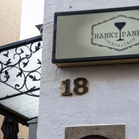 Ein Schild mit der Aufschrift 'Hanky Panky Cocktail & co' h&auml;ngt an einer Hauswand neben der Hausnummer 18. Eine Laterne und ein dekoratives Vordach sind sichtbar., &copy; Stuttgart-Marketing GmbH, Sarah Schmid