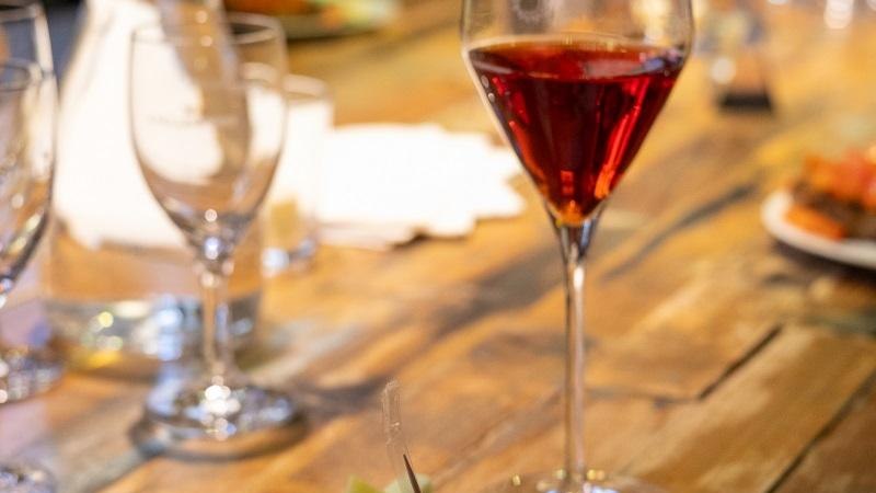 Ein Glas Rotwein steht auf einem Holztisch neben einem Teller mit Bruschetta und Käsewürfeln., © Tourist Information und Ticket Service Ludwigsburg Ein Glas Rotwein steht auf einem Holztisch neben einem Teller mit Bruschetta und Käsewürfeln., © Tourist Information und Ticket Service Ludwigsburg