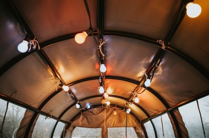 Innenansicht eines Zeltdachs mit bunten Lichtern, die an den Streben befestigt sind. Die Lichter schaffen eine warme Atmosphäre., © Cool-Tours StattReisen