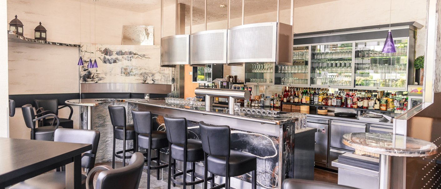 Moderne Bar mit schwarzen Hockern, gut bestückter Theke und Gläsern im Hintergrund. Stilvolle Beleuchtung und Dekoration., © PLAZA Hotelgroup GmbH Moderne Bar mit schwarzen Hockern, gut bestückter Theke und Gläsern im Hintergrund. Stilvolle Beleuchtung und Dekoration., © PLAZA Hotelgroup GmbH