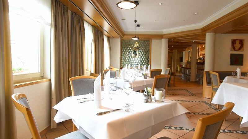 Ein elegantes Restaurant mit wei&szlig;en Tischdecken, Holzst&uuml;hlen und gro&szlig;en Fenstern. Die Einrichtung ist modern mit warmen Holzt&ouml;nen., &copy; Hotel am Park