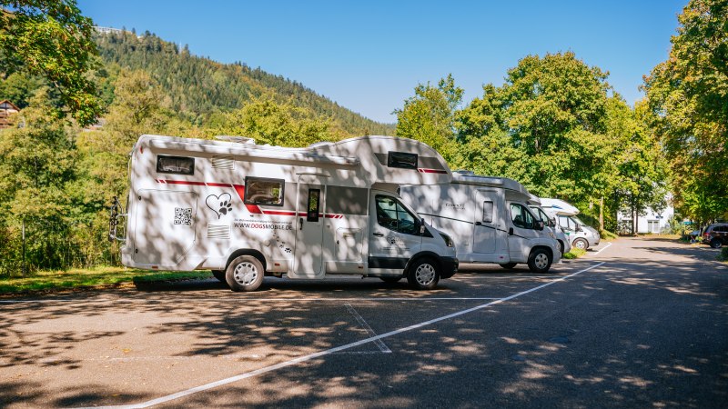 Wohnmobilstellplatz in Bad Wildbad mit mehreren Wohnmobilen, umgeben von Bäumen und Bergen bei sonnigem Wetter., © Stuttgart-Marketing GmbH, Thomas Niedermüller Wohnmobilstellplatz in Bad Wildbad mit mehreren Wohnmobilen, umgeben von Bäumen und Bergen bei sonnigem Wetter., © Stuttgart-Marketing GmbH, Thomas Niedermüller