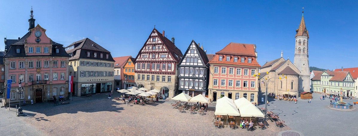 Historischer Marktplatz mit Fachwerkhäusern, Rathaus und Johanniskirche unter blauem Himmel. Menschen sitzen in Cafés und genießen die Atmosphäre., © Für die Bildrechte: Amt für Medien und Kommunikation Schwäbisch Gmünd Historischer Marktplatz mit Fachwerkhäusern, Rathaus und Johanniskirche unter blauem Himmel. Menschen sitzen in Cafés und genießen die Atmosphäre., © Für die Bildrechte: Amt für Medien und Kommunikation Schwäbisch Gmünd