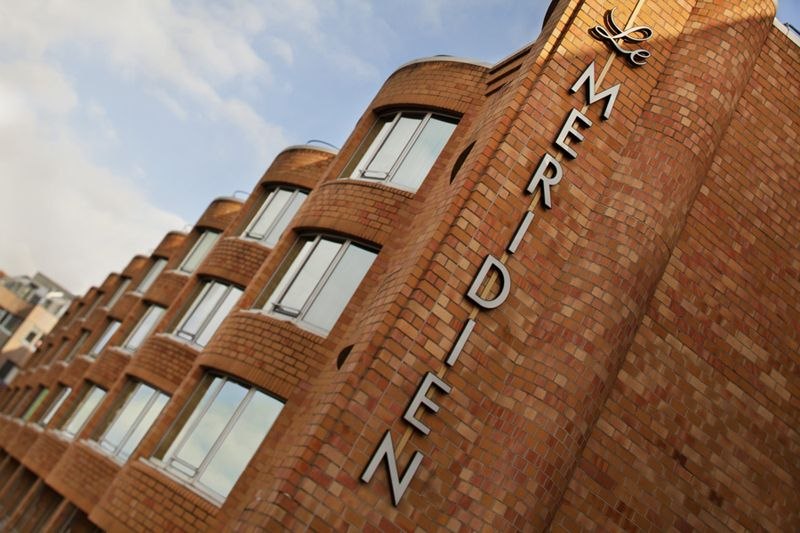 Backsteinfassade des Le Méridien Stuttgart mit großen Fenstern und Schriftzug. Der Himmel ist leicht bewölkt., © Hotel Le Méridien