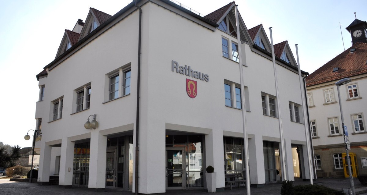 Das Nufringer Rathaus mit moderner Architektur, wei&szlig;en W&auml;nden und roten Dachziegeln. Vor dem Geb&auml;ude stehen Fahnenmasten., &copy; Natur.Nah. Sch&ouml;nbuch & Heckeng&auml;u