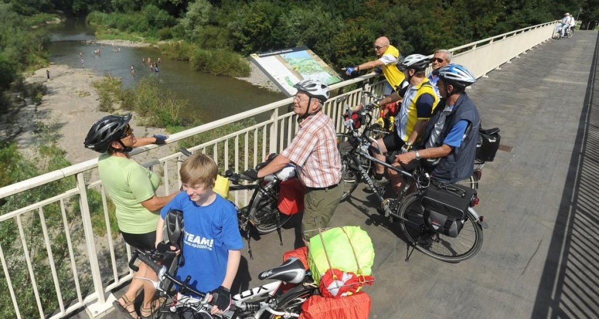 Radfahrer auf einer Br&uuml;cke &uuml;ber den Altneckar, betrachten die Landschaft. Im Hintergrund sind Menschen im Wasser zu sehen., &copy; Aktiv-Region Stuttgart