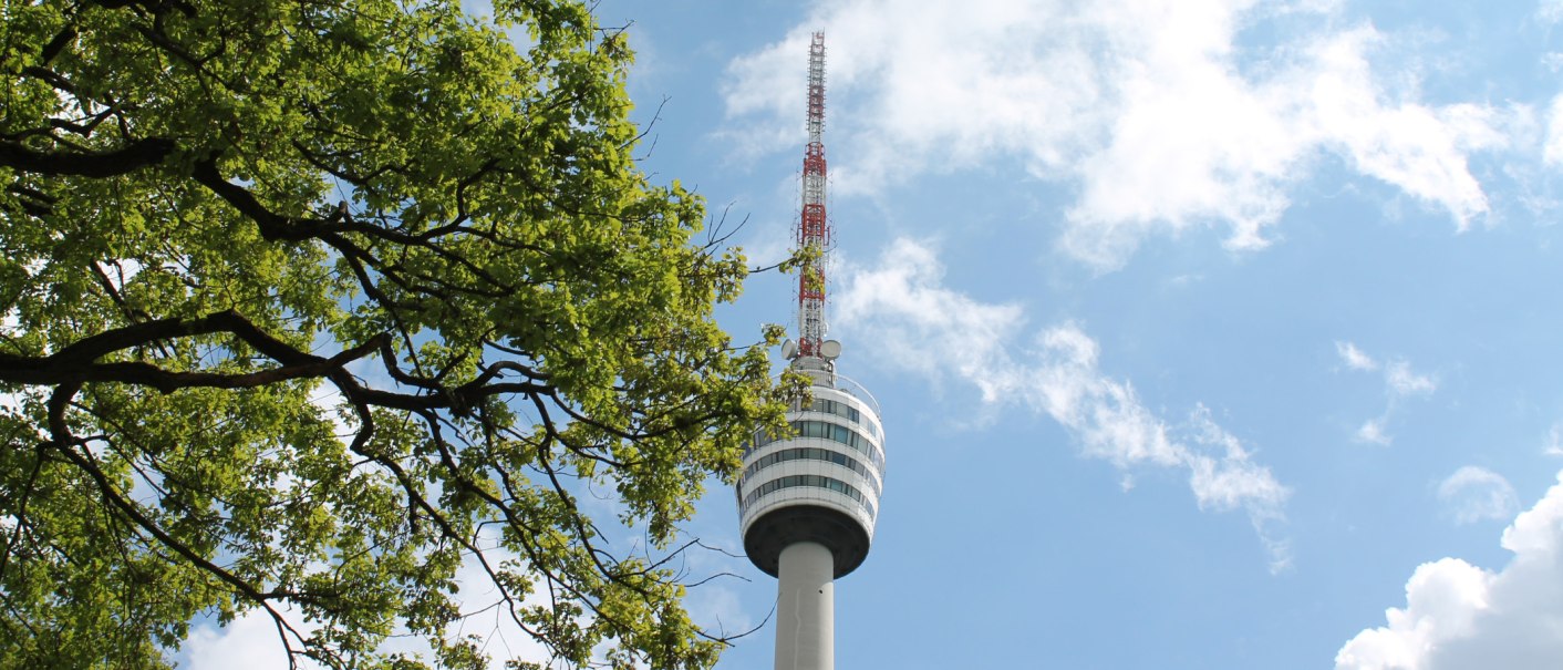 Der Fernsehturm Stuttgart ragt in den blauen Himmel, umgeben von grünen Baumzweigen., © Stuttgart-Marketing GmbH Der Fernsehturm Stuttgart ragt in den blauen Himmel, umgeben von grünen Baumzweigen., © Stuttgart-Marketing GmbH