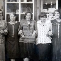 F&uuml;nf Frauen in Vintage-Kleidung stehen Arm in Arm vor einem Gesch&auml;ft. Eine sechste Person schaut aus dem Fenster. Die Szene wirkt freundlich und nostalgisch., &copy; Eigenbetrieb Tourismus und Citymanagement Schorndorf