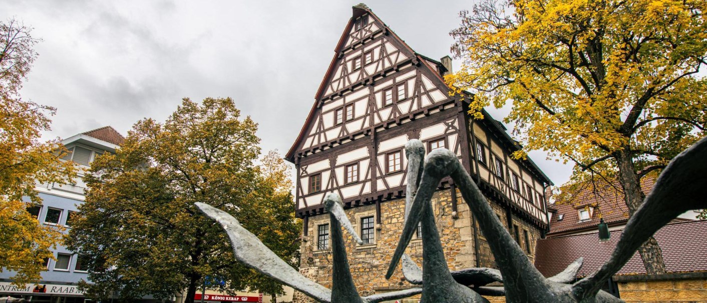 Das Städtische Museum im Storchen in Göppingen zeigt ein Fachwerkhaus mit einer Skulptur im Vordergrund und herbstlich gefärbten Bäumen., © Stuttgart-Marketing GmbH, Sarah Schmid Das Städtische Museum im Storchen in Göppingen zeigt ein Fachwerkhaus mit einer Skulptur im Vordergrund und herbstlich gefärbten Bäumen., © Stuttgart-Marketing GmbH, Sarah Schmid