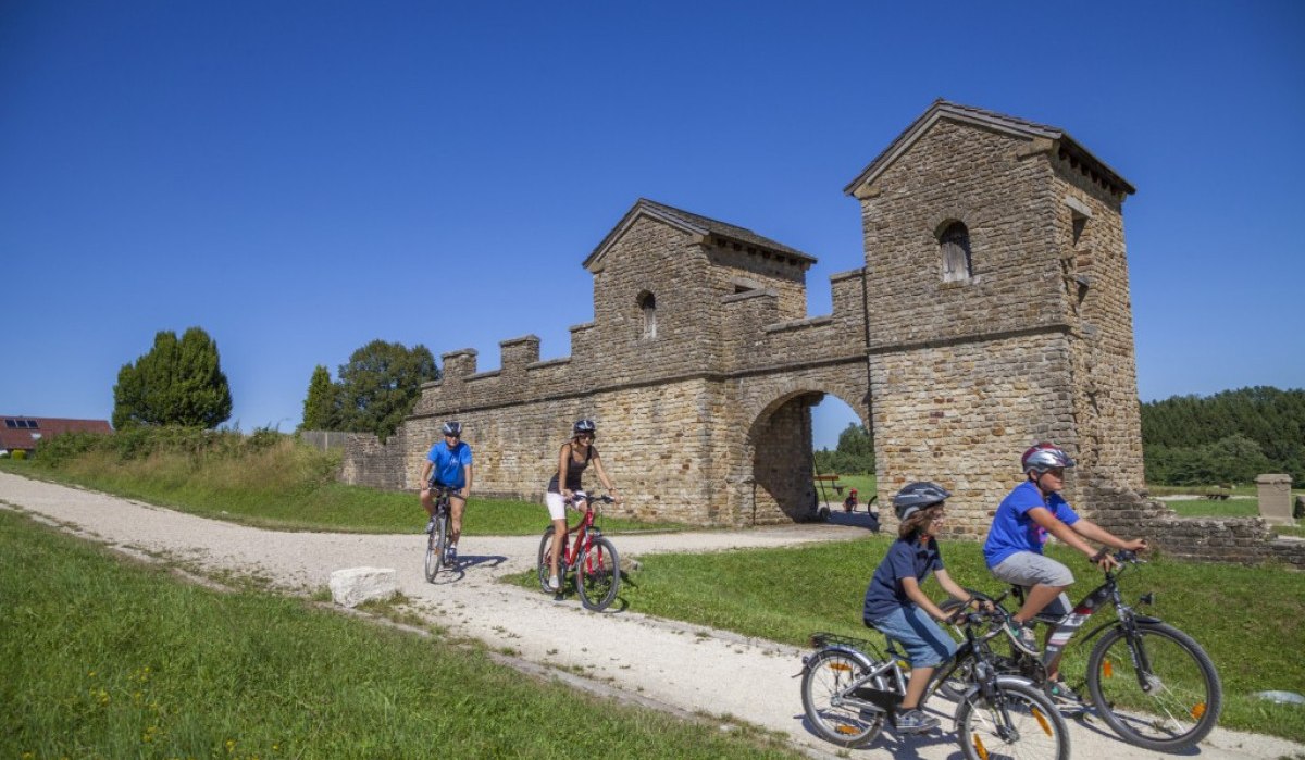 Radfahrer fahren auf einem Weg vor dem historischen Ostkastell in Welzheim. Der Himmel ist klar und blau., &copy; Stadt Welzheim