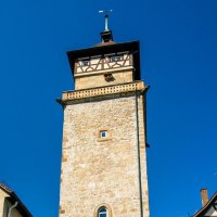 Der Hochwachturm in Waiblingen ragt zwischen zwei Fachwerkhäusern in den blauen Himmel empor., © SMG, Sarah Schmid Der Hochwachturm in Waiblingen ragt zwischen zwei Fachwerkhäusern in den blauen Himmel empor., © SMG, Sarah Schmid