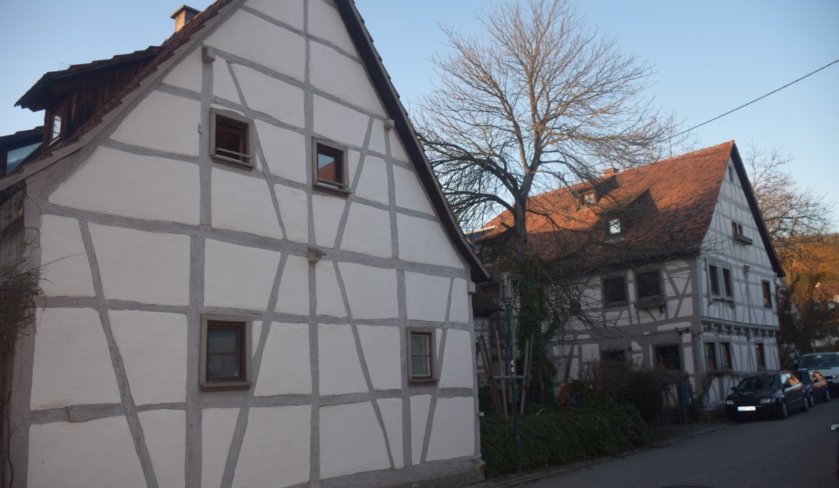 Zwei Fachwerkhäuser in einer ländlichen Straße, umgeben von kahlen Bäumen und parkenden Autos., © Land der 1000 Hügel - Kraichgau-Stromberg Zwei Fachwerkhäuser in einer ländlichen Straße, umgeben von kahlen Bäumen und parkenden Autos., © Land der 1000 Hügel - Kraichgau-Stromberg