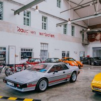 Innenansicht der Motorworld Region Stuttgart mit klassischen Autos und Motorrädern in einer Halle mit hohen Decken und einem Kronleuchter., © Stuttgart-Marketing GmbH, Thomas Niedermüller