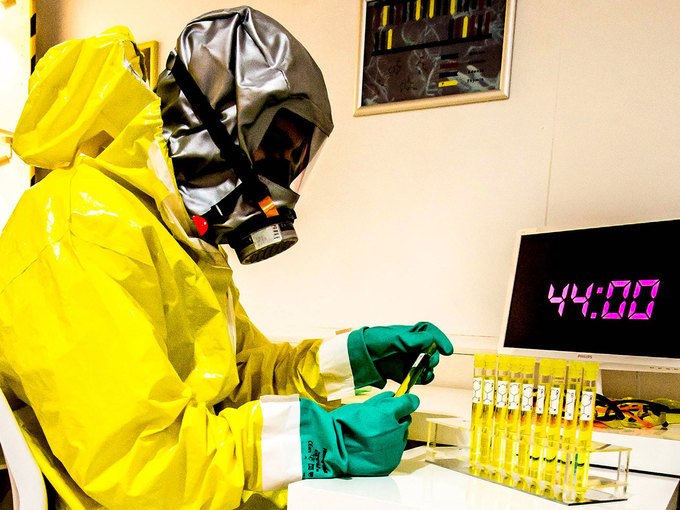 Person in gelbem Schutzanzug und Atemmaske arbeitet mit Proben. Ein Timer zeigt 44:00 an. Laborumgebung mit Reagenzgläsern., © ExitGames Stuttgart Person in gelbem Schutzanzug und Atemmaske arbeitet mit Proben. Ein Timer zeigt 44:00 an. Laborumgebung mit Reagenzgläsern., © ExitGames Stuttgart
