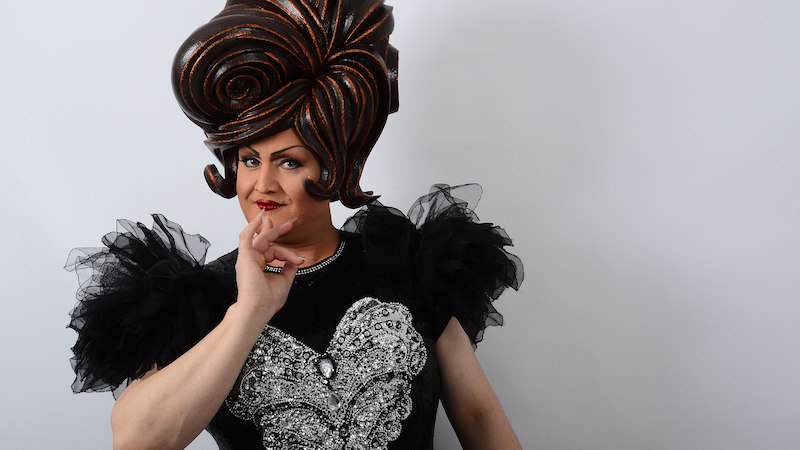 Person mit gro&szlig;er, kunstvoller Per&uuml;cke und schwarzem Kleid mit silbernen Verzierungen posiert vor wei&szlig;em Hintergrund., &copy; Kurverwaltung Bad Urach