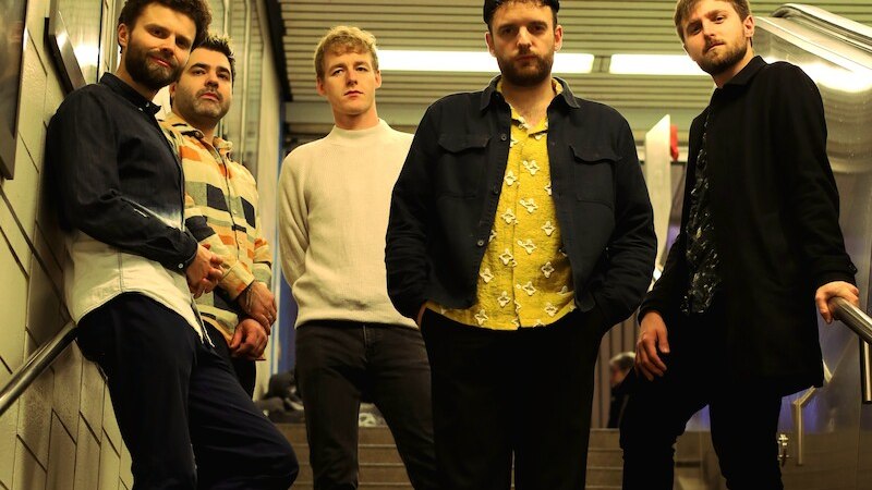 F&uuml;nf M&auml;nner posieren l&auml;ssig auf einer Treppe in einer U-Bahn-Station. Sie tragen verschiedene modische Outfits und schauen in die Kamera., &copy; Mauerwerk GmbH