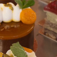 Nahaufnahme von kunstvoll dekorierten Kuchen in einer Vitrine. Verschiedene Toppings wie Fr&uuml;chte und Sahne sind zu sehen., &copy; SMG