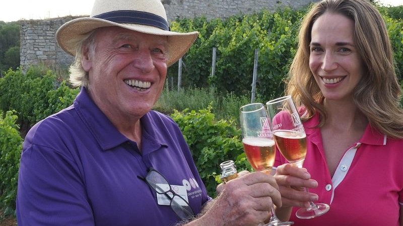 Zwei Personen stoßen mit Sektgläsern in einem Weinberg an. Im Hintergrund ist eine alte Steinruine zu sehen., © © Tourismus & Events Ludwigsburg Zwei Personen stoßen mit Sektgläsern in einem Weinberg an. Im Hintergrund ist eine alte Steinruine zu sehen., © © Tourismus & Events Ludwigsburg